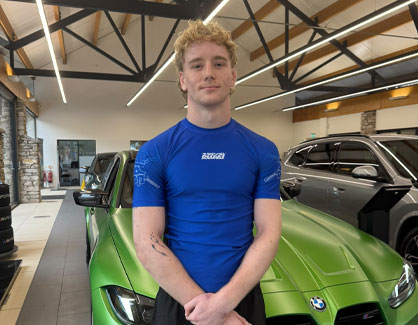 Sam Holladay standing with BMW in Lloyd South Lakes Showroom