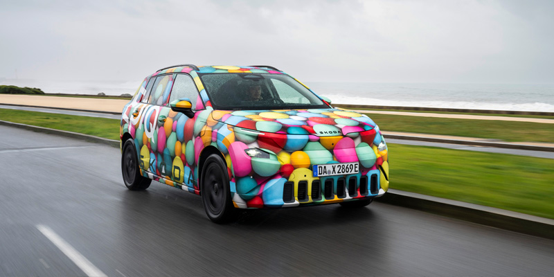 Skoda Peaq driving in countryside with grey cloudy background